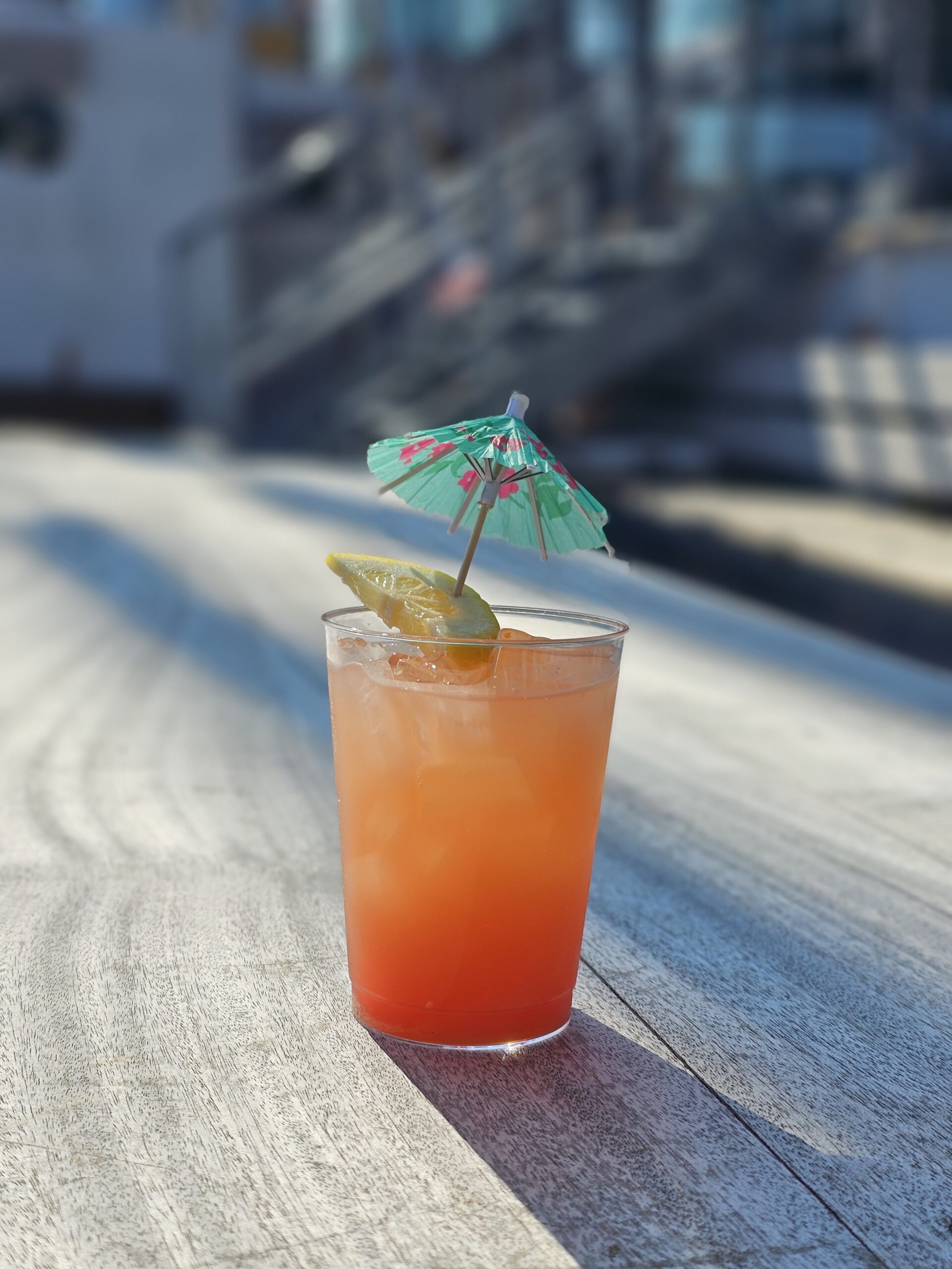 A glass of Dan Seavey's Best Punch with an umbrella on the deck of Tall Ship Windy