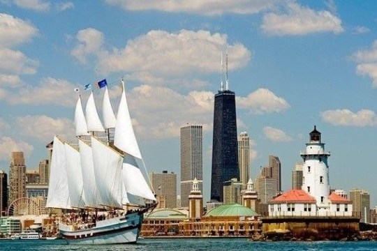 a large ship in a body of water with a city in the background